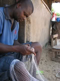 Fisherman repairs nets
